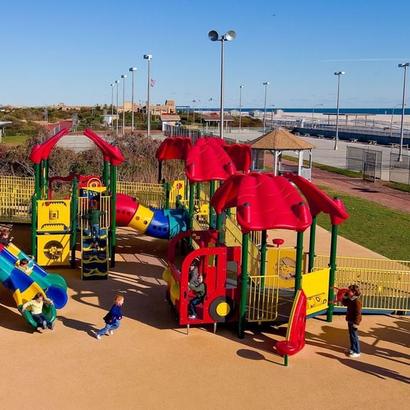 aerial view of red and yellow colored park with children playing on it